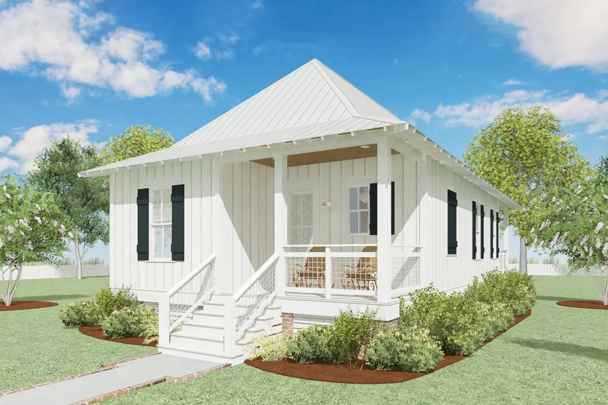 White exterior paint covers the cottage's front, which is surrounded by landscaping.