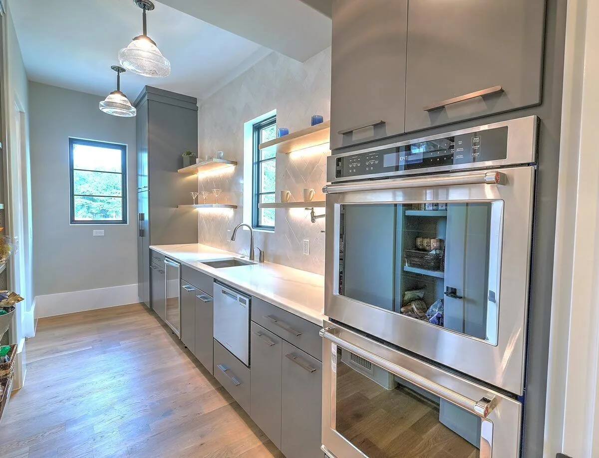 Counter area with a sleek design, lovely backsplash, and wood racks.
