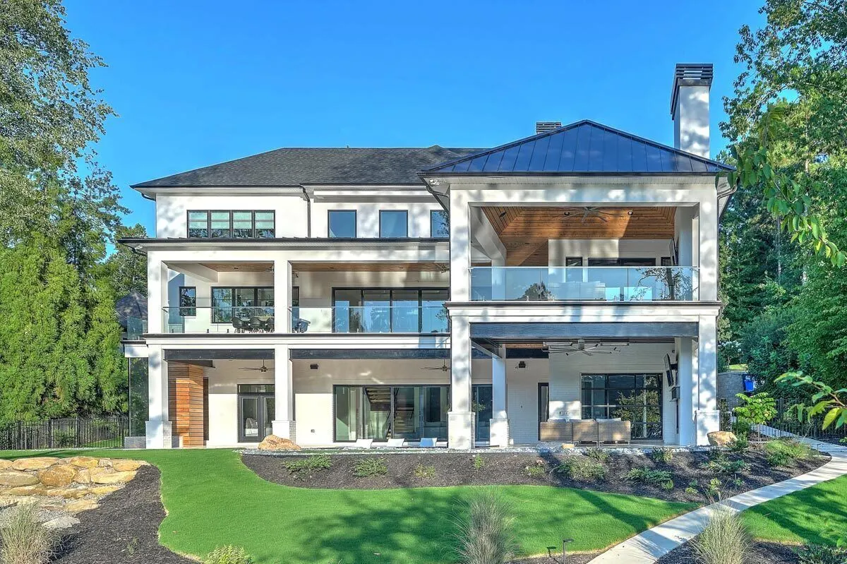 The back of the home features a magnificent covered patio guarded by a glass fence.