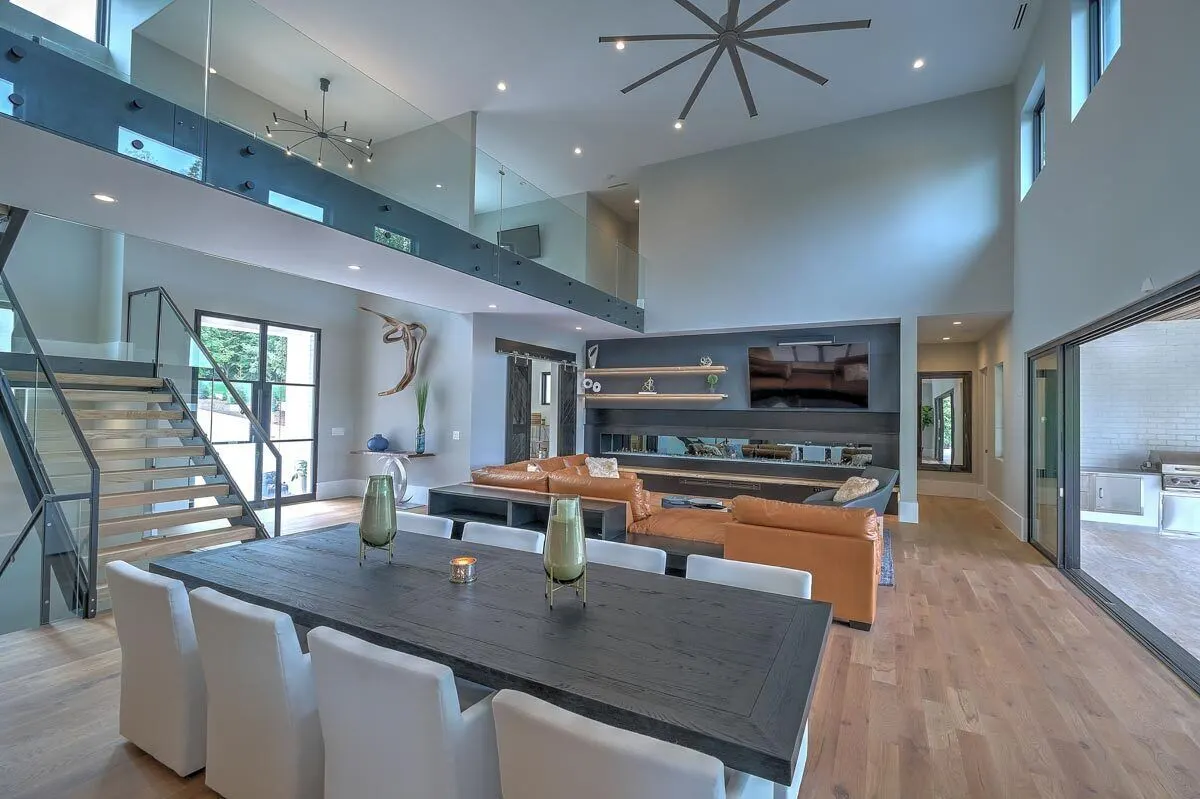 Dining space with a rustic wooden table and eight gray-covered seats.