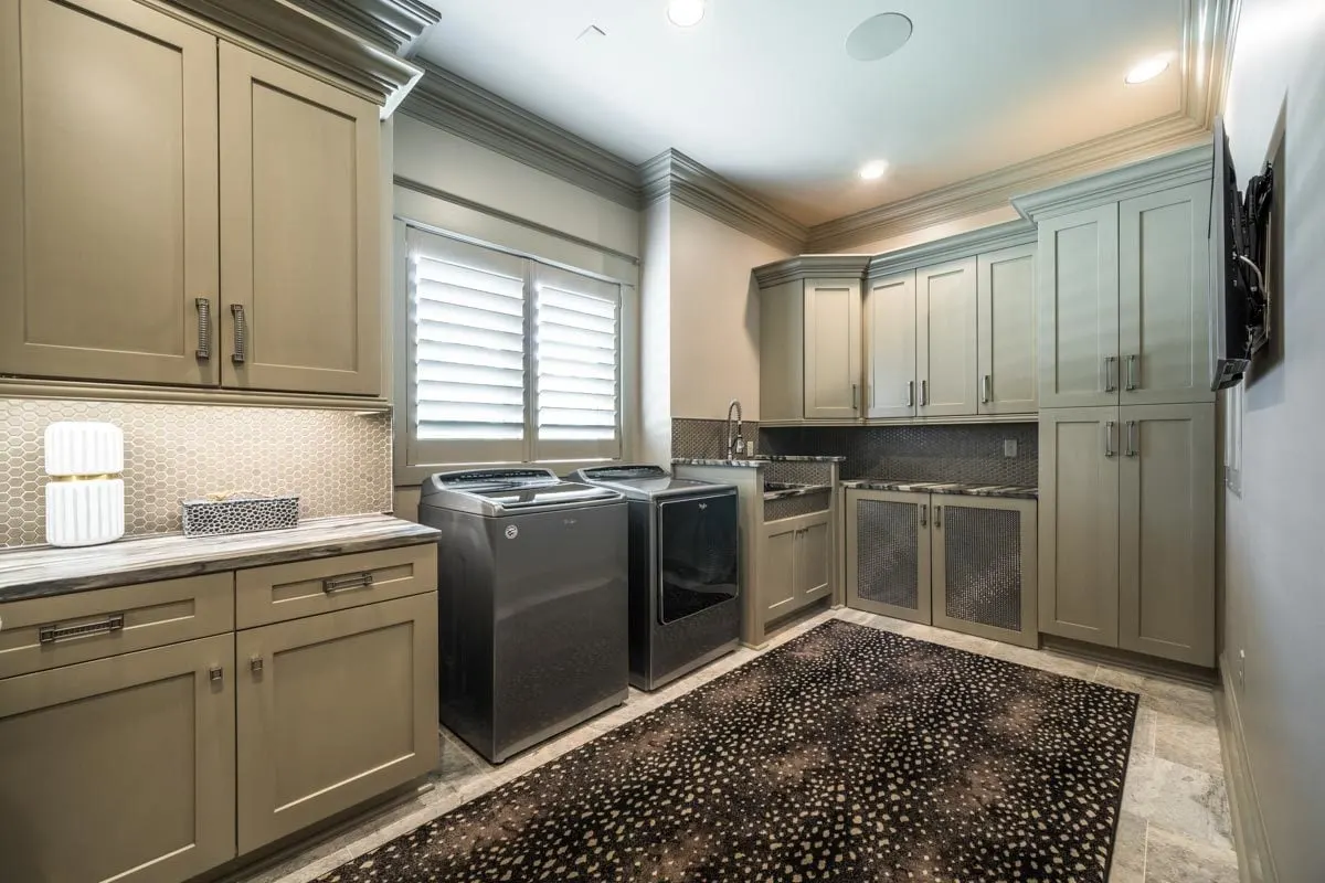The laundry room is equipped with washing, a dryer, and cabinetry.