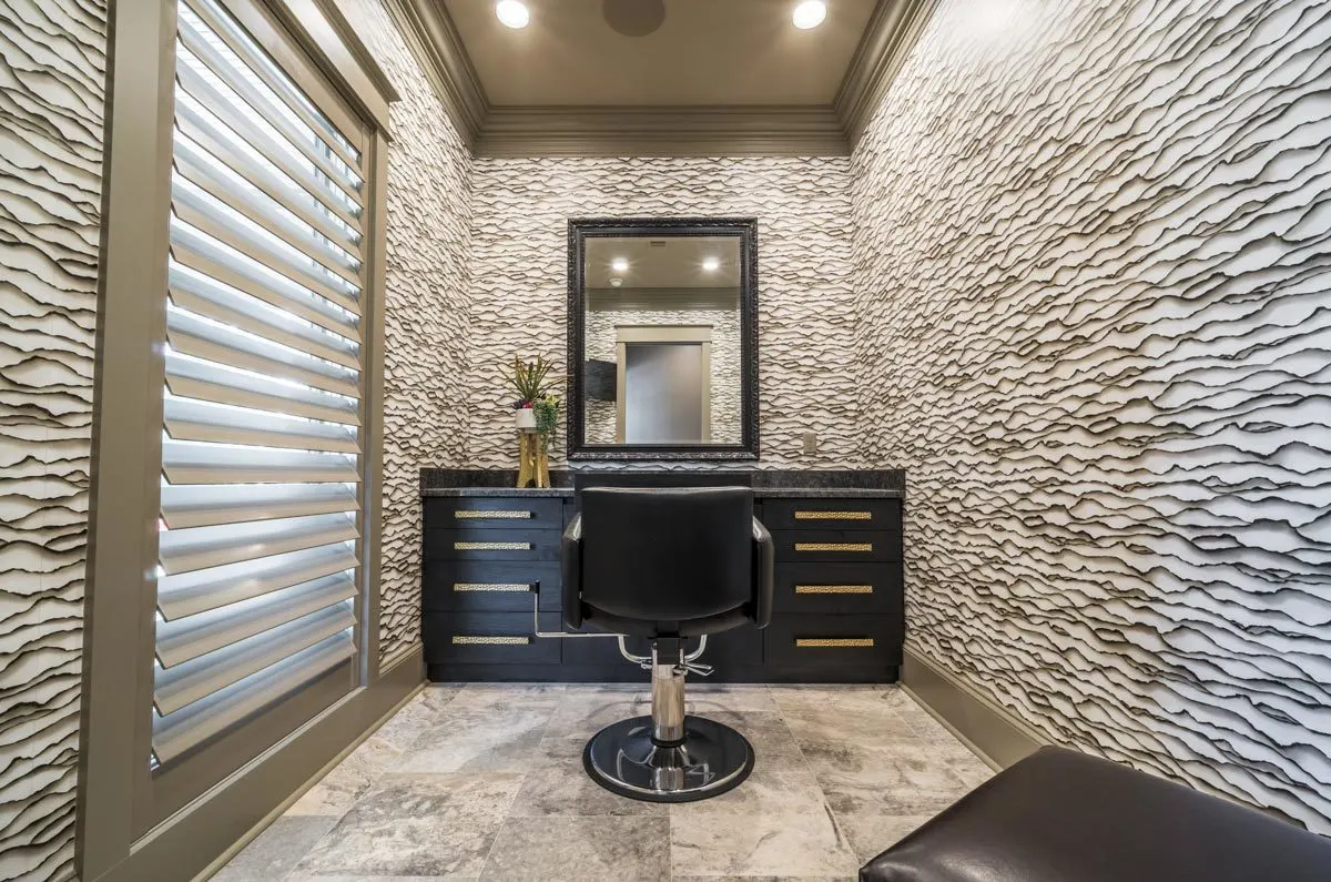 Salon space with creatively designed walls and black furniture.