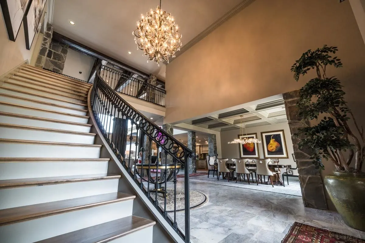 The staircase has a sleek design with a wood accent and black metal railings.