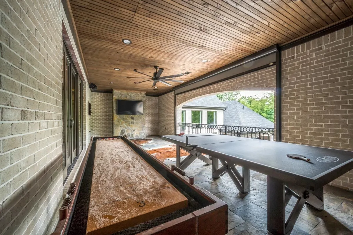 Outdoor living space with a wood accent ceiling and a brick-style wall.