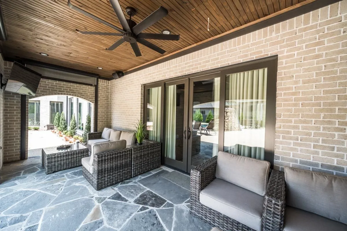 Covered porch with matching couches and sliding glass doors.