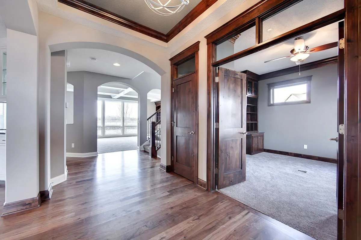 Study space with a broad double door design entry and wooden accent shelving inside.