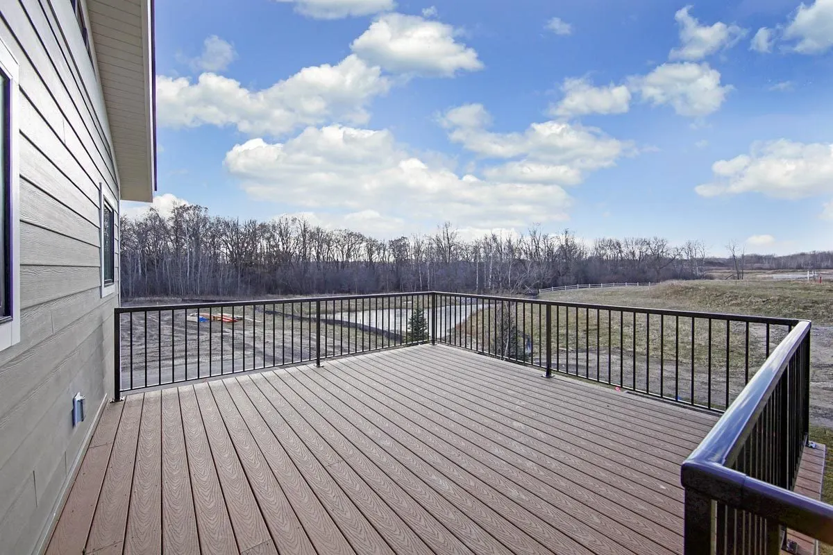 The deck area, which features a hardwood floor and black metal railings.