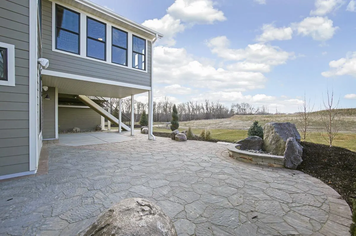 A nice sight of the second level's four-season porch area with the stone patio.