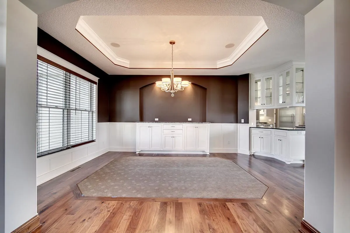 An elegant dining room with a central chandelier.