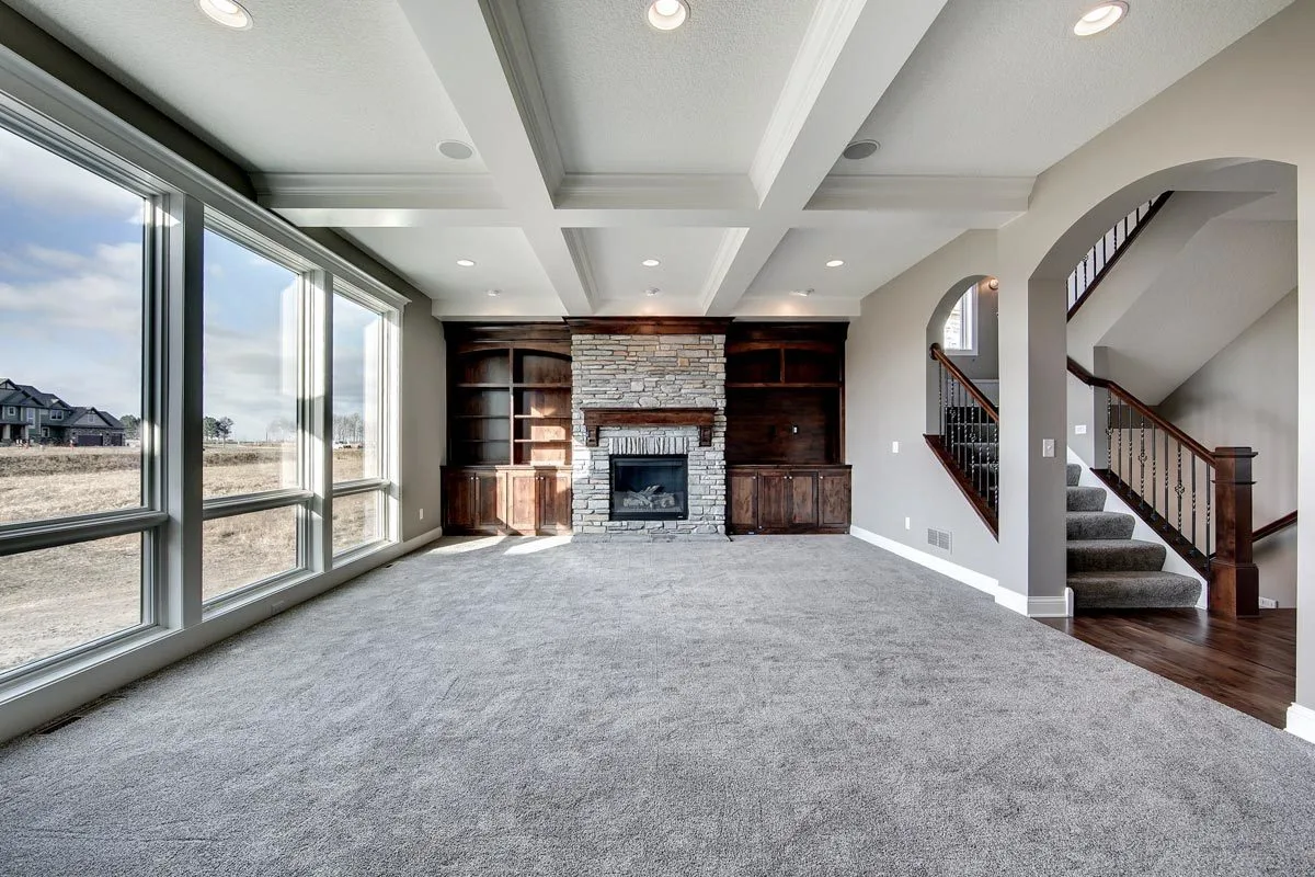 A wonderful room setting with a gorgeous ceiling design and large windows that provide light to the room.