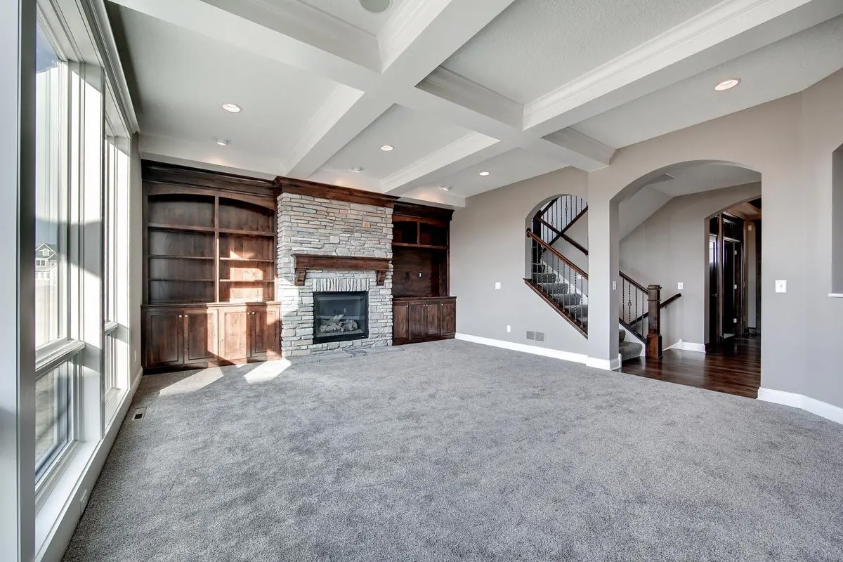 A fireplace with a stone foundation and side shelving.