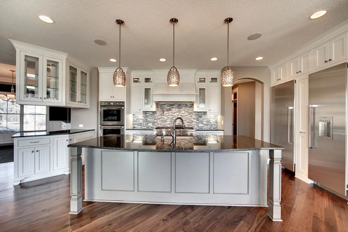 The gray kitchen island has a marble counter with a sink.