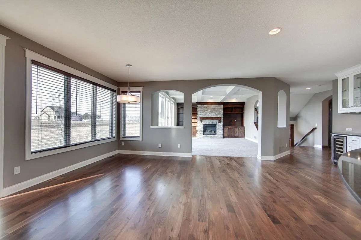 The dining space features a large window with roller shutters and an above pendant chandelier.
