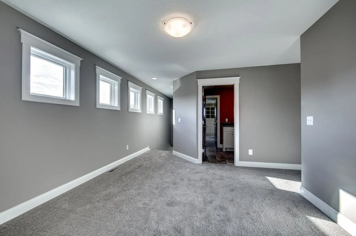 A room in the house with gray walls and white trim around the windows and entrance.