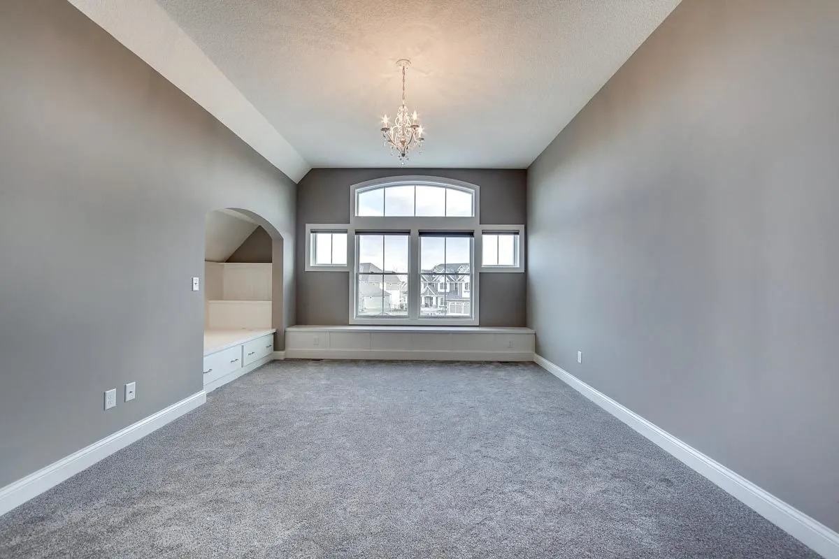 A brilliant chandelier and window with a lovely design brings the space to life.