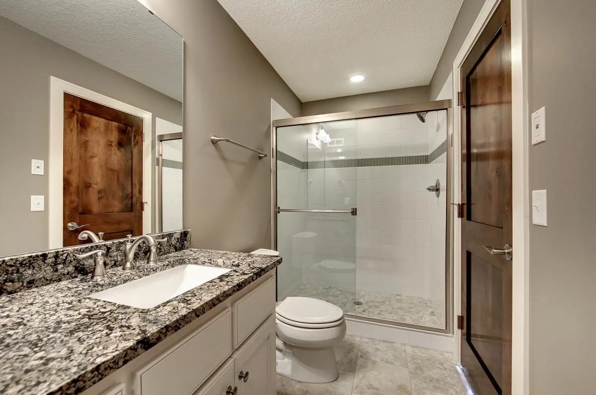 Bathroom featuring a sink, a toilet, and a shower in glass frame.