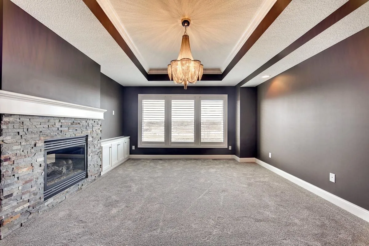 The master suite has a black metal fireplace with a see-through glass cover.