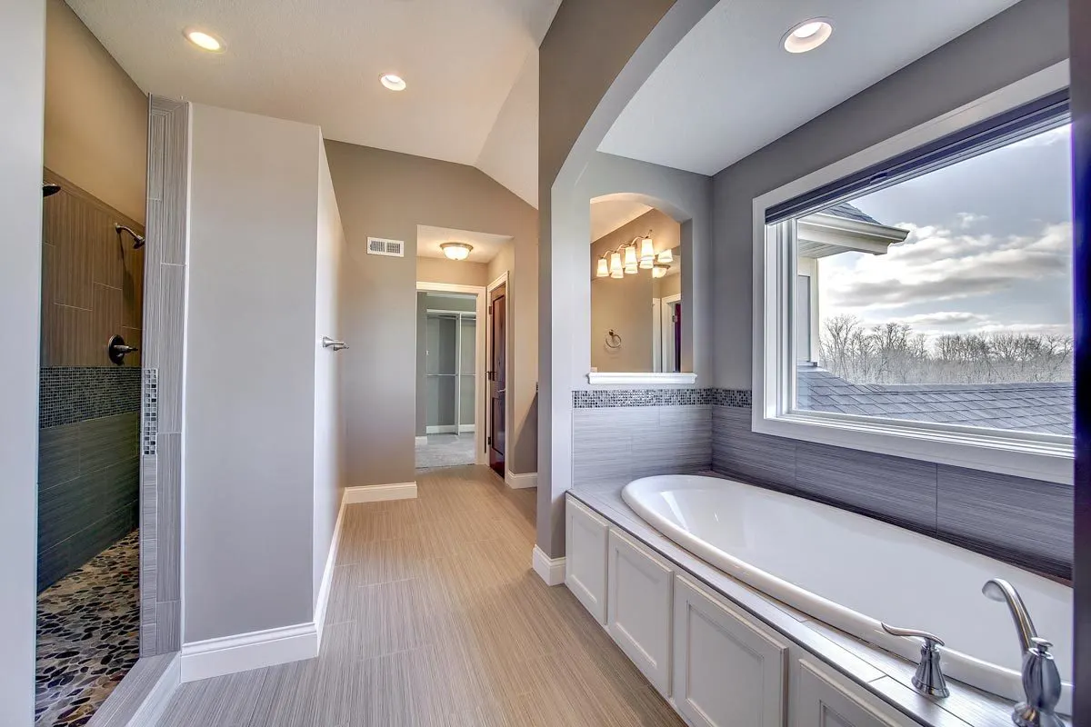 A large window in the bathtub area provides a glimpse of the outside.