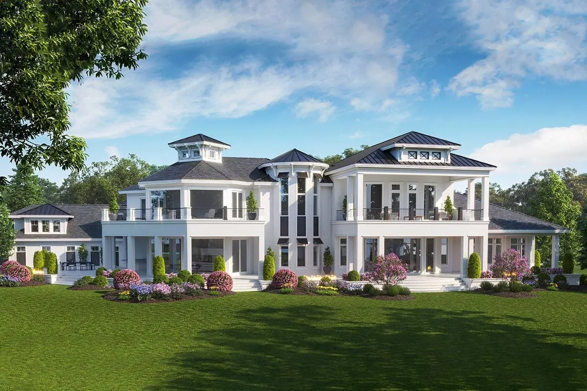 Back of the luxury home with lanai, balcony, and landscape features.