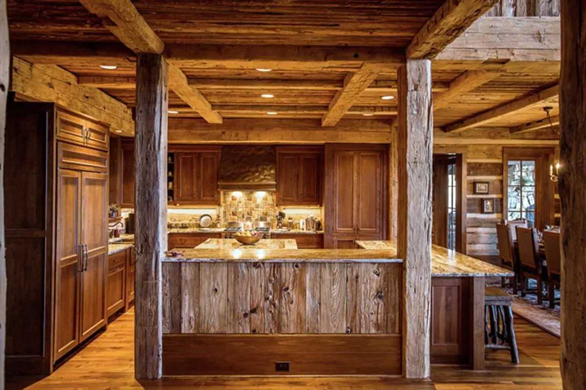 The kitchen area has a ceiling with exposed wood beams and sturdy columns.