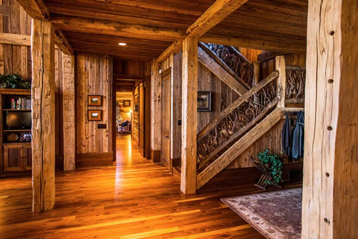 The hallway has polished wood flooring and a stairway to the second level.