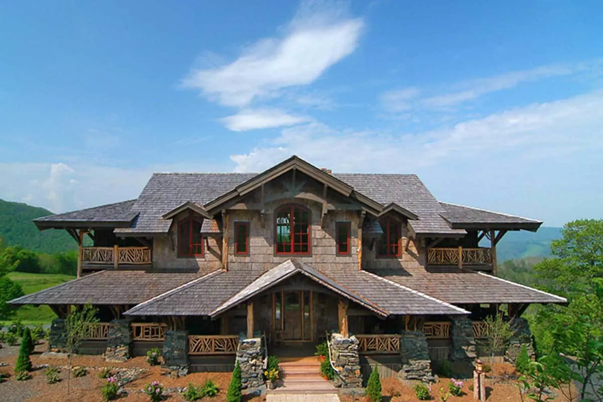 A full view of the rustic mountain house with beautiful front landscaping.