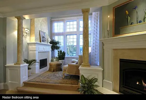Two fireplace features in the master bedroom with marble accent posts.