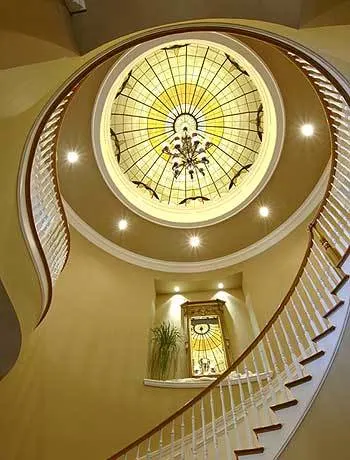 The house has a beautiful rotunda design with white and wood accent styles.