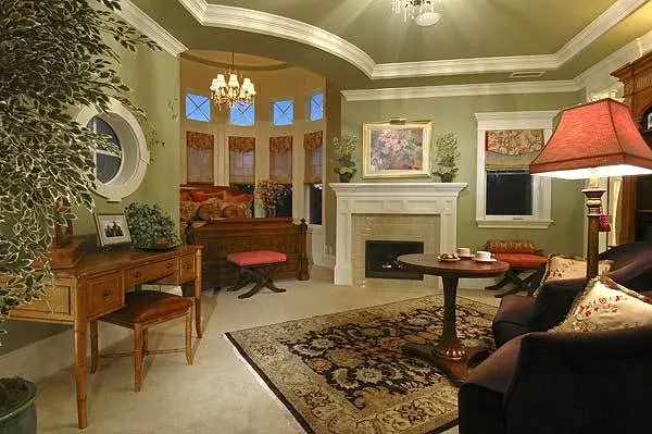 Guest room with a sitting area and walls painted a light shade of green.