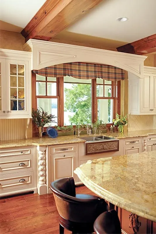 The kitchen sink with white cabinets and countertops.