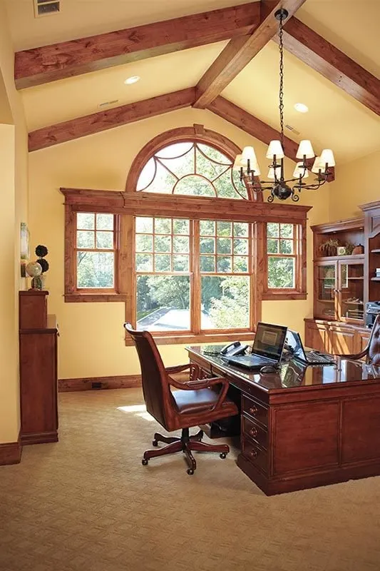Home Office with an elegant chandelier and huge framed windows.