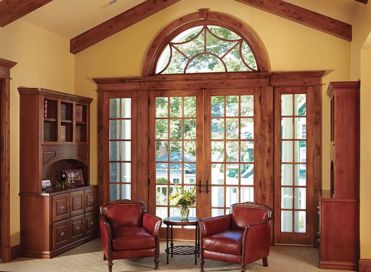 Antique cabinet and chairs that complements the huge wooden framed glass door.