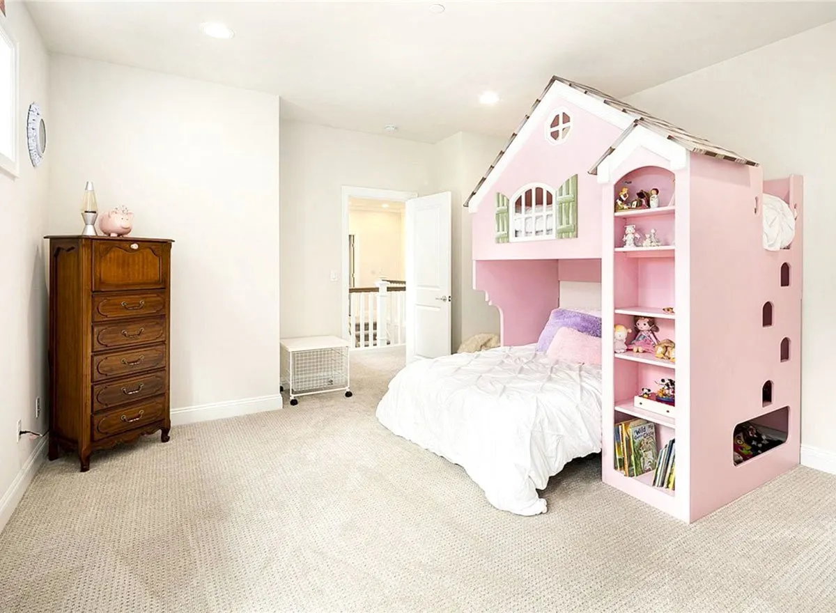 A girl's room with a fashionable pink home bed and white painted walls.