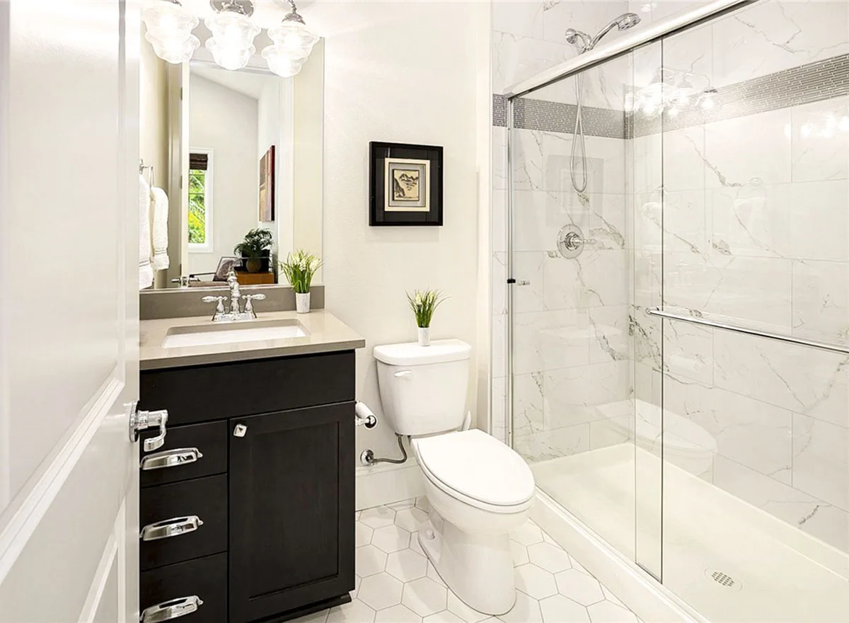 Bathroom with vanity, toilet, and glass sliding door shower.