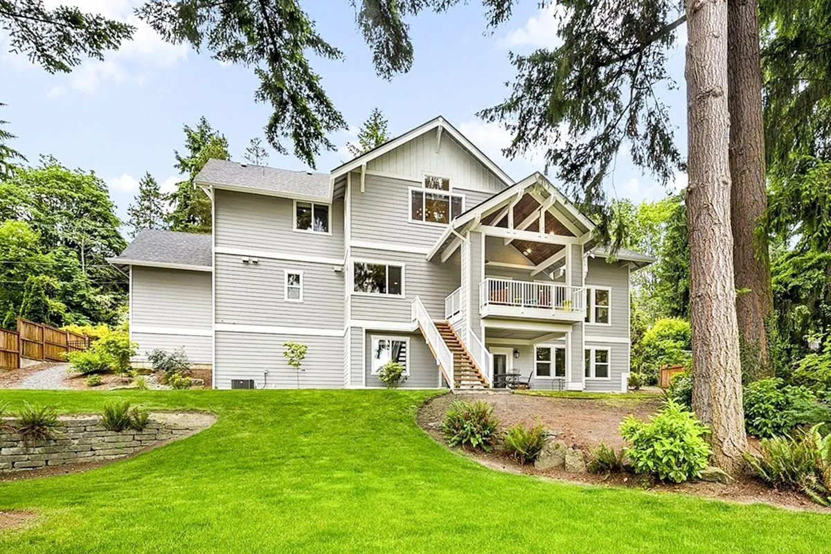 A back picture of a light gray exterior paint house with a stairway to the deck area.
