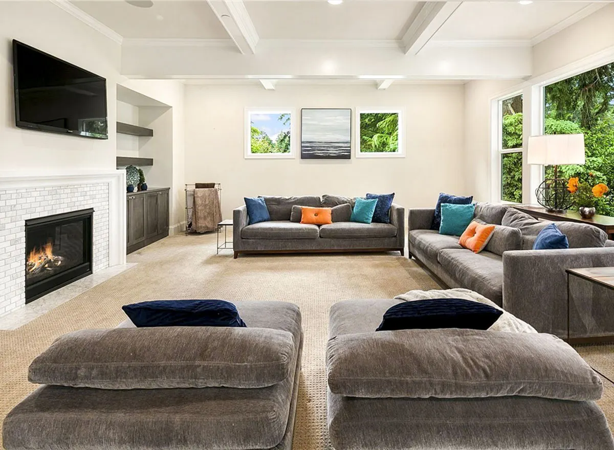 Great room space with gray velvet sofas and a white exposed wood beam ceiling.