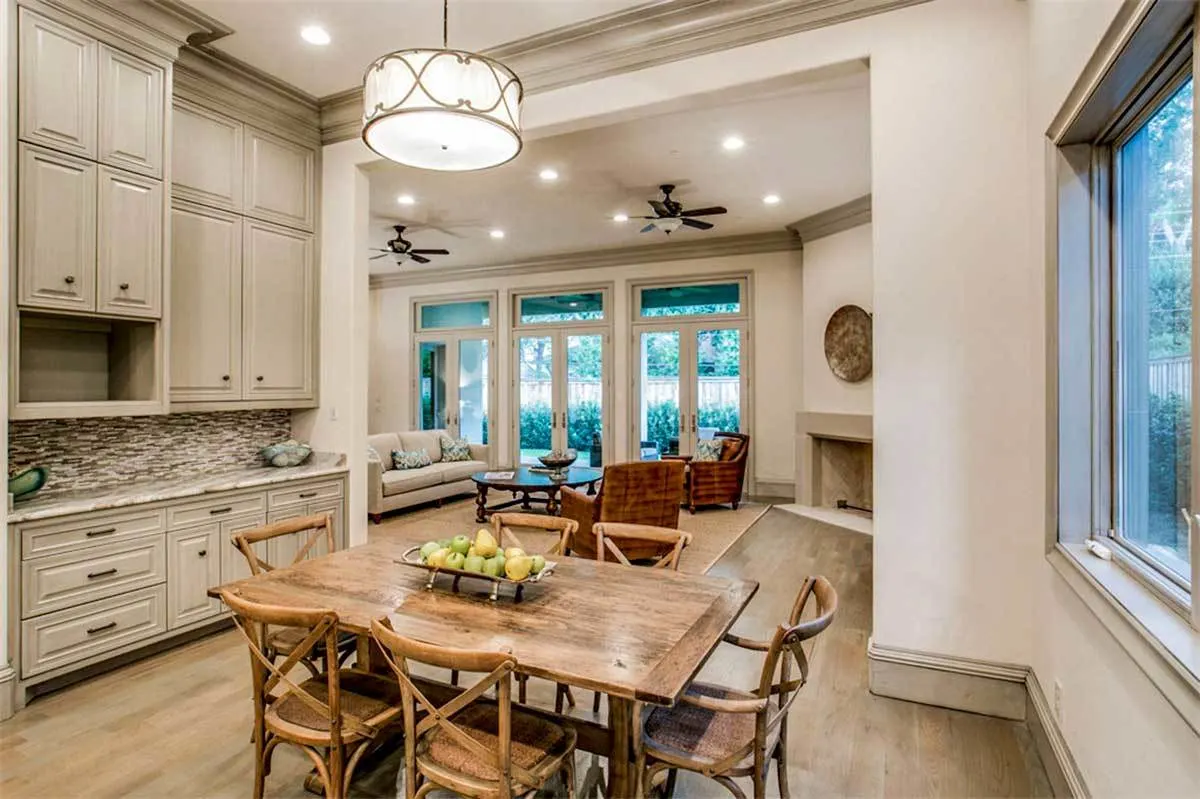 A breakfast nook by the window with a wooden design table and chairs.