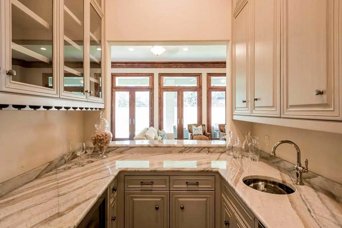 The bar area in U-shape features a marble counter with a sink.