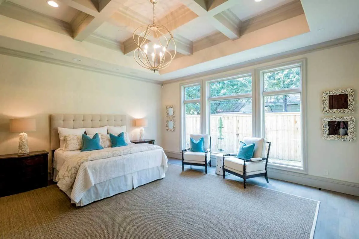 A gorgeous bedroom with touch of blue color, well-lit by the large windows.