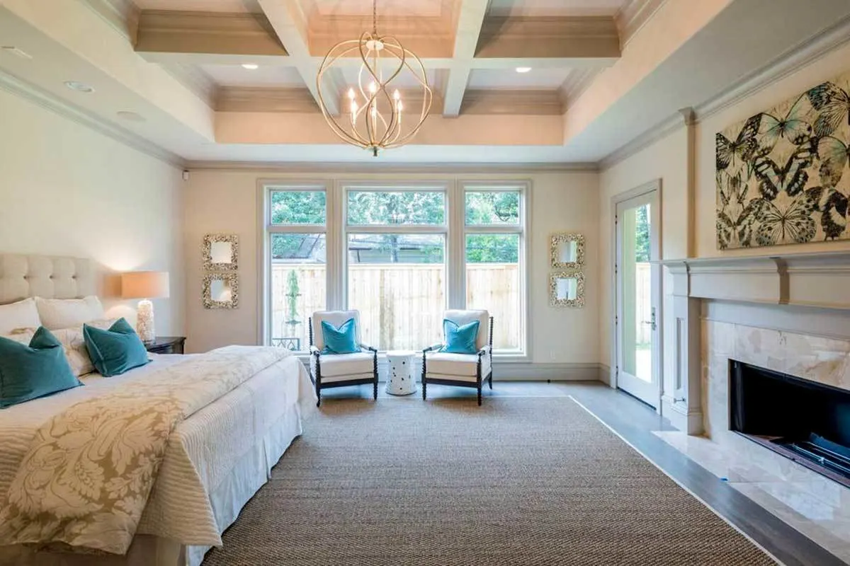 The bedroom has a linear fireplace and a circular chandelier.