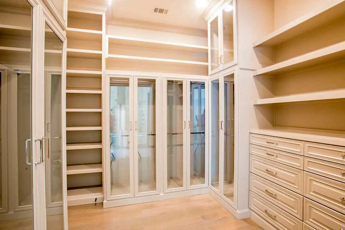 Walk-in closet with glass door in an efficient style clothing storage.