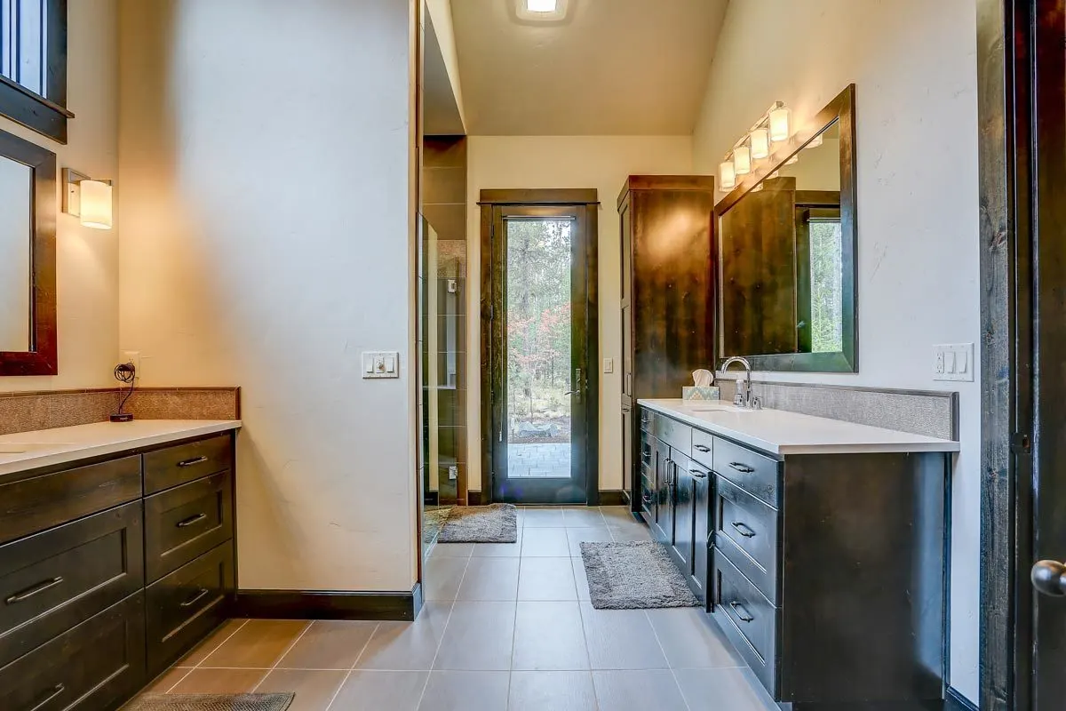 The master bathroom has two vanities and a door to the terrace.