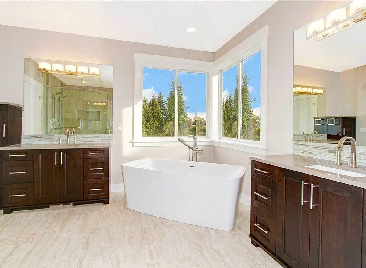 The master bathroom with two sink and a bathtub in the middle.