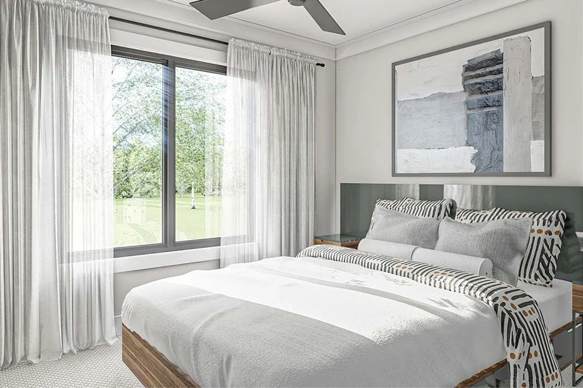 The bedroom is bright in tone and offers a view of the outdoors through a huge window.