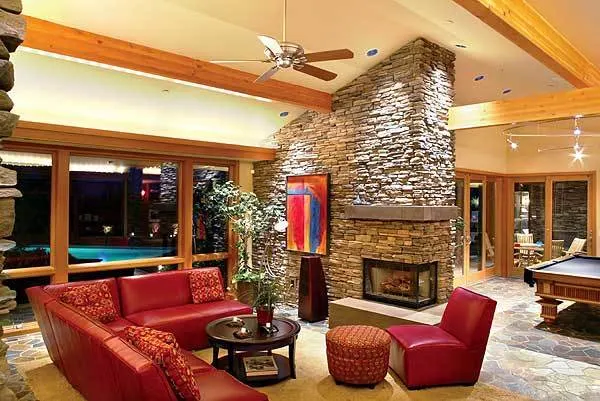 The living room features a cherry leather sofa and a rounded center table.