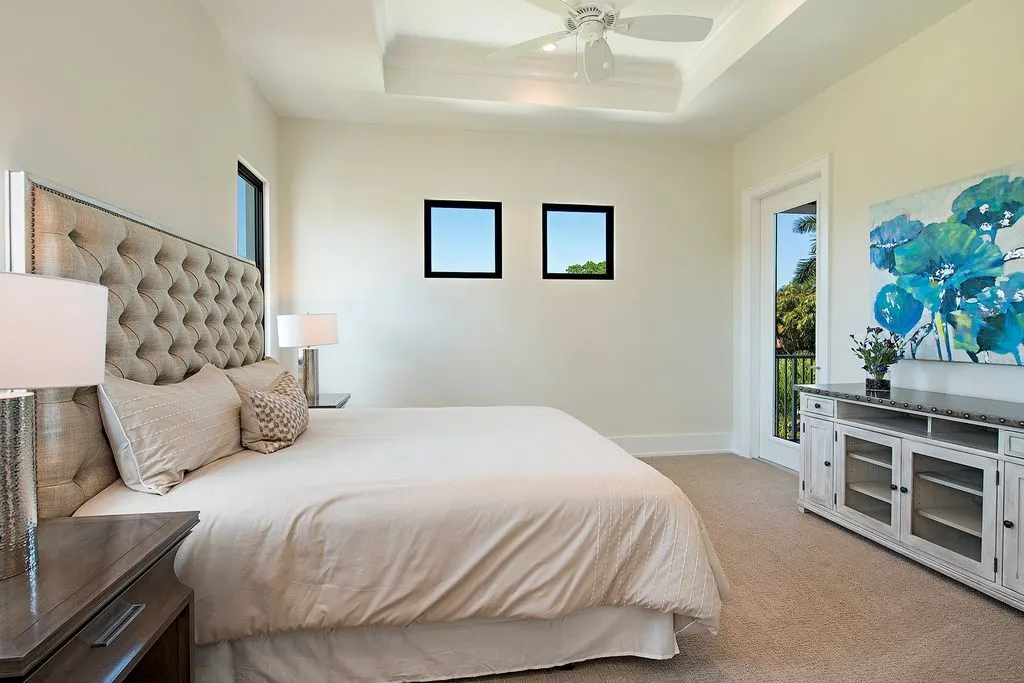 Another bedroom space with an elegant bed and tables and a vibrant blue paint wall.