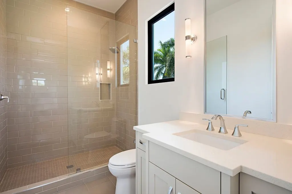 Bathroom features shower with glass enclosure, toilet, and vanity.