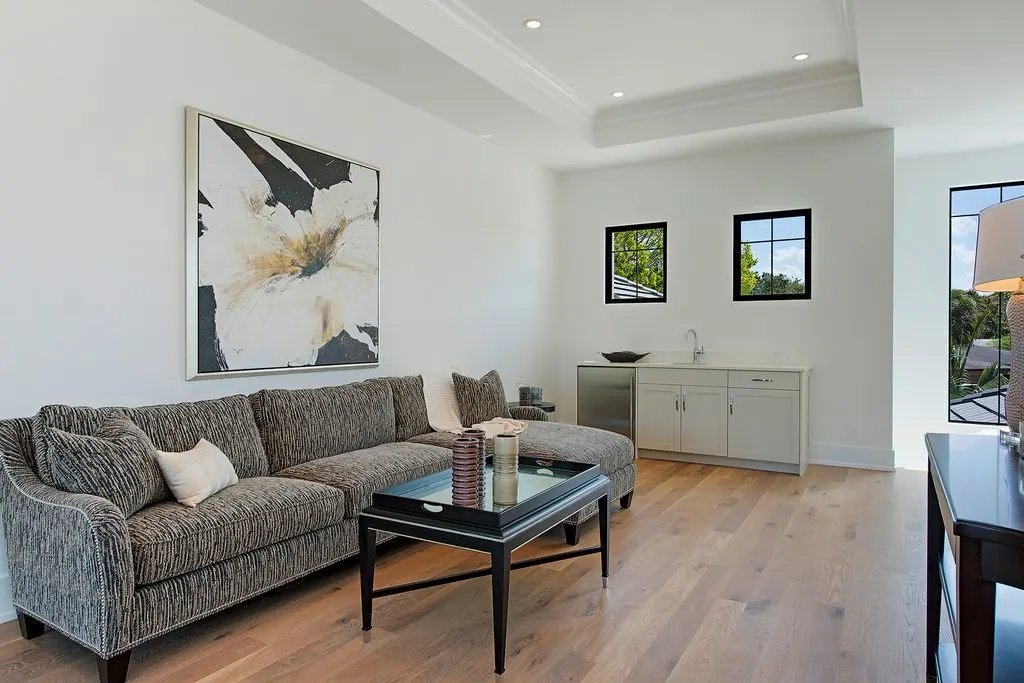 L-shaped gray sofa with a black center table and elegant candles.
