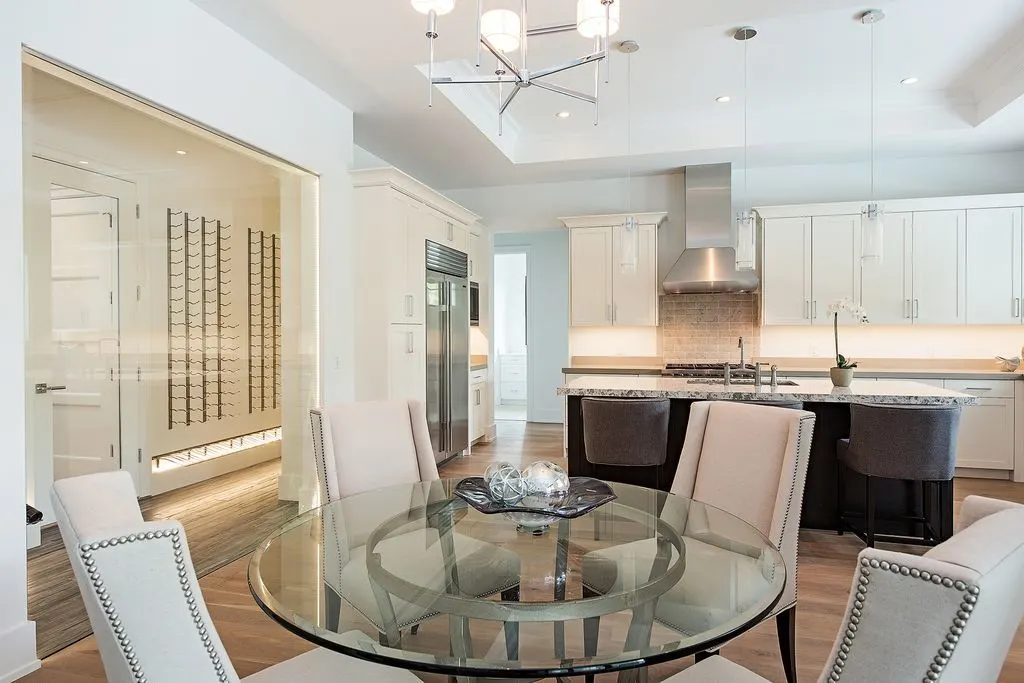 A glass table with a stylish chair beside the kitchen.