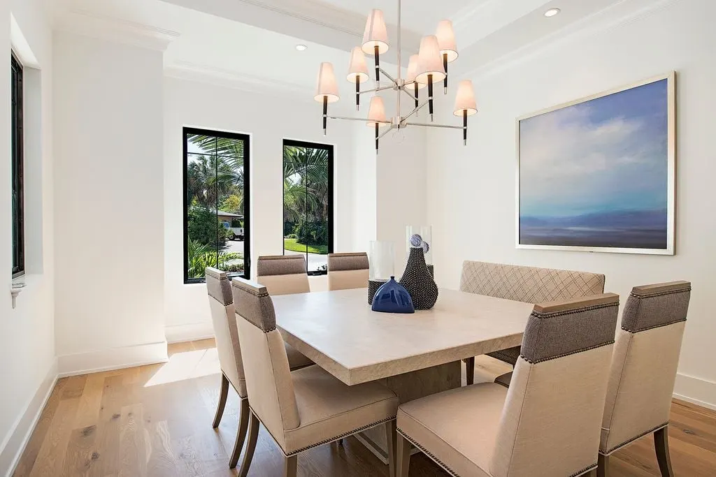 Dining table in beige color design with stylish lighting above.